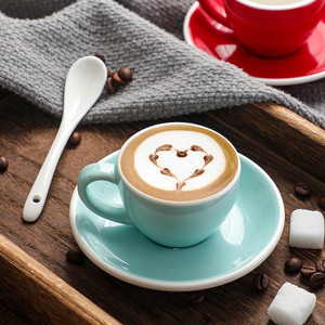 Las tazas multicoloras del café express de la porcelana 75ml con los platillos abultan las fuentes de la cocina