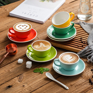 Las tazas multicoloras del café express de la porcelana 75ml con los platillos abultan las fuentes de la cocina