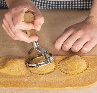 Molde de acero inoxidable de los raviolis con la manija de madera usada para hacer las bolas de masa hervida italianas