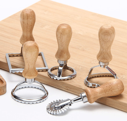 Molde de acero inoxidable de los raviolis con la manija de madera usada para hacer las bolas de masa hervida italianas