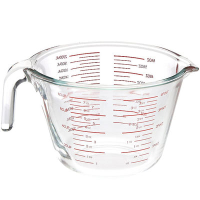 Taza de medición de cristal de la cocina que cuece con los gráficos rojos microonda y horno